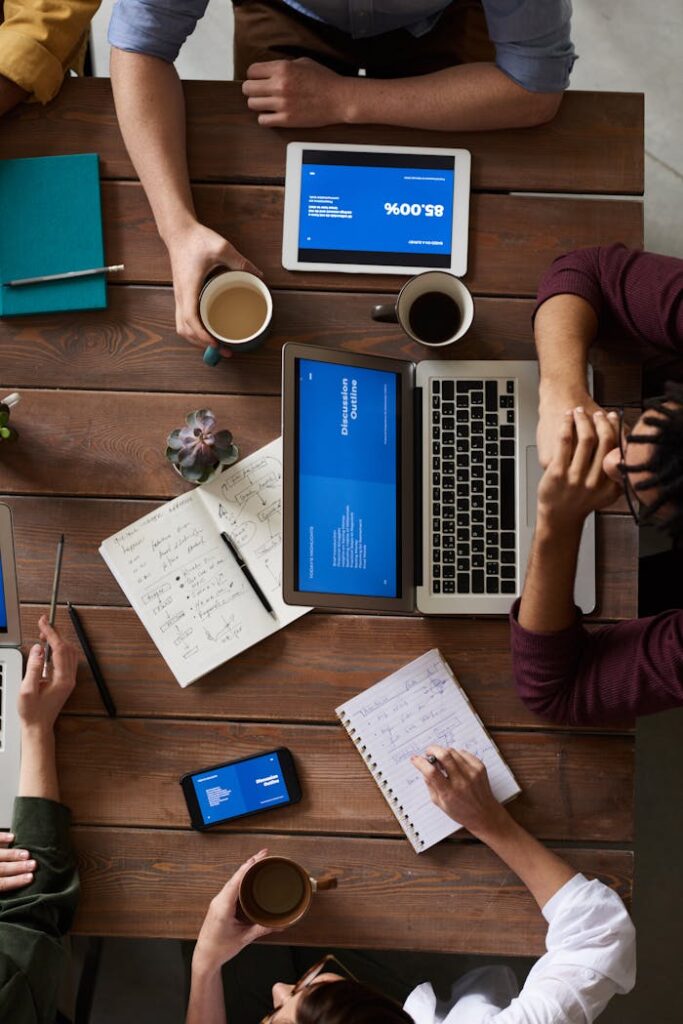Groupe de collaborateurs discutant autour d'un PC